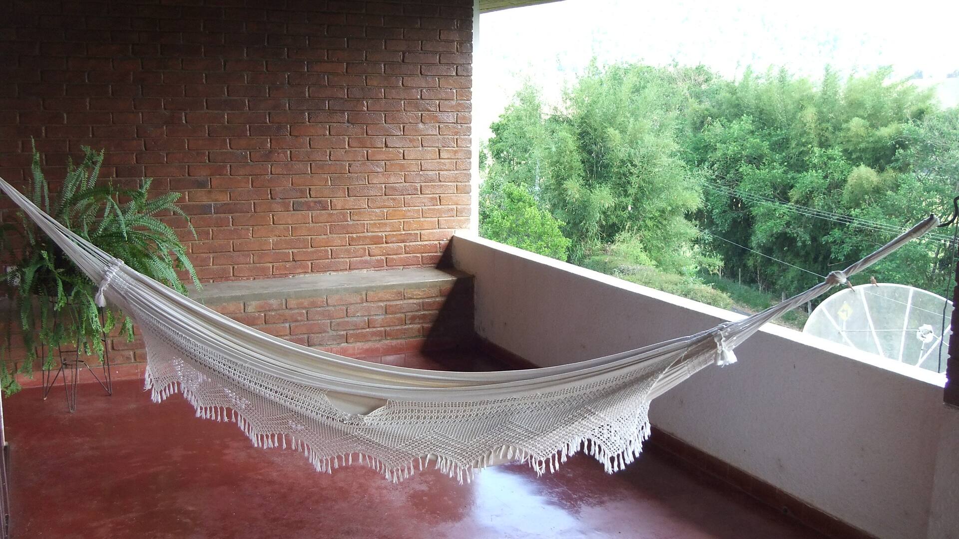 Rede na varanda da Casa Capelinha com vista para o verde